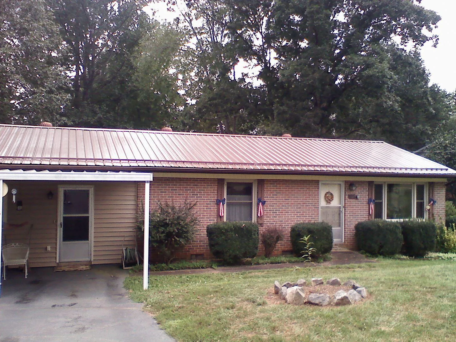 Bronze metal roof and carport on a brick ranch home — Roof Repair work by our crew in Woodbine